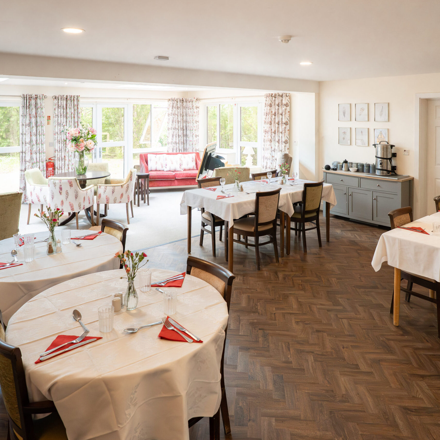 Sunny dining room with tables laid for lunch at Tudor Lodge