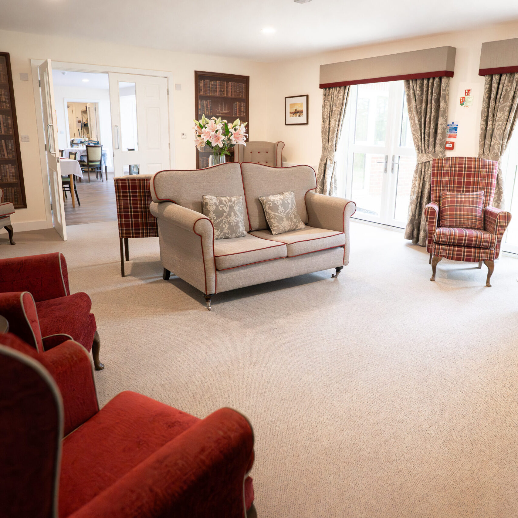 Bright lounge with sofas and armchairs at Tudor Lodge