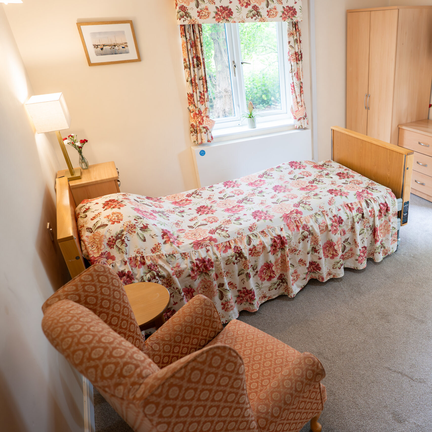 Resident's bedroom with a floral bedspread at Tudor Lodge
