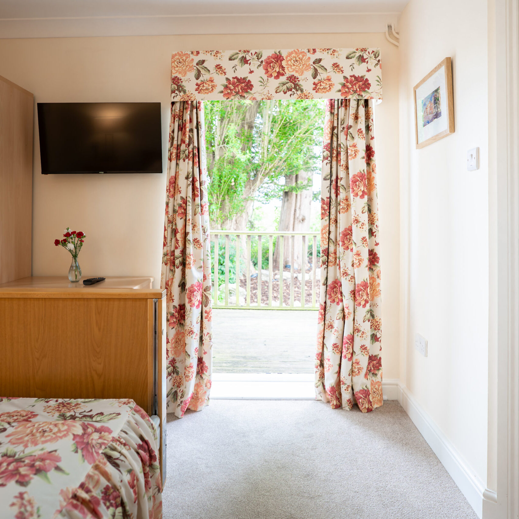 Resident's bedroom with patio doors onto the garden at Tudor Lodge
