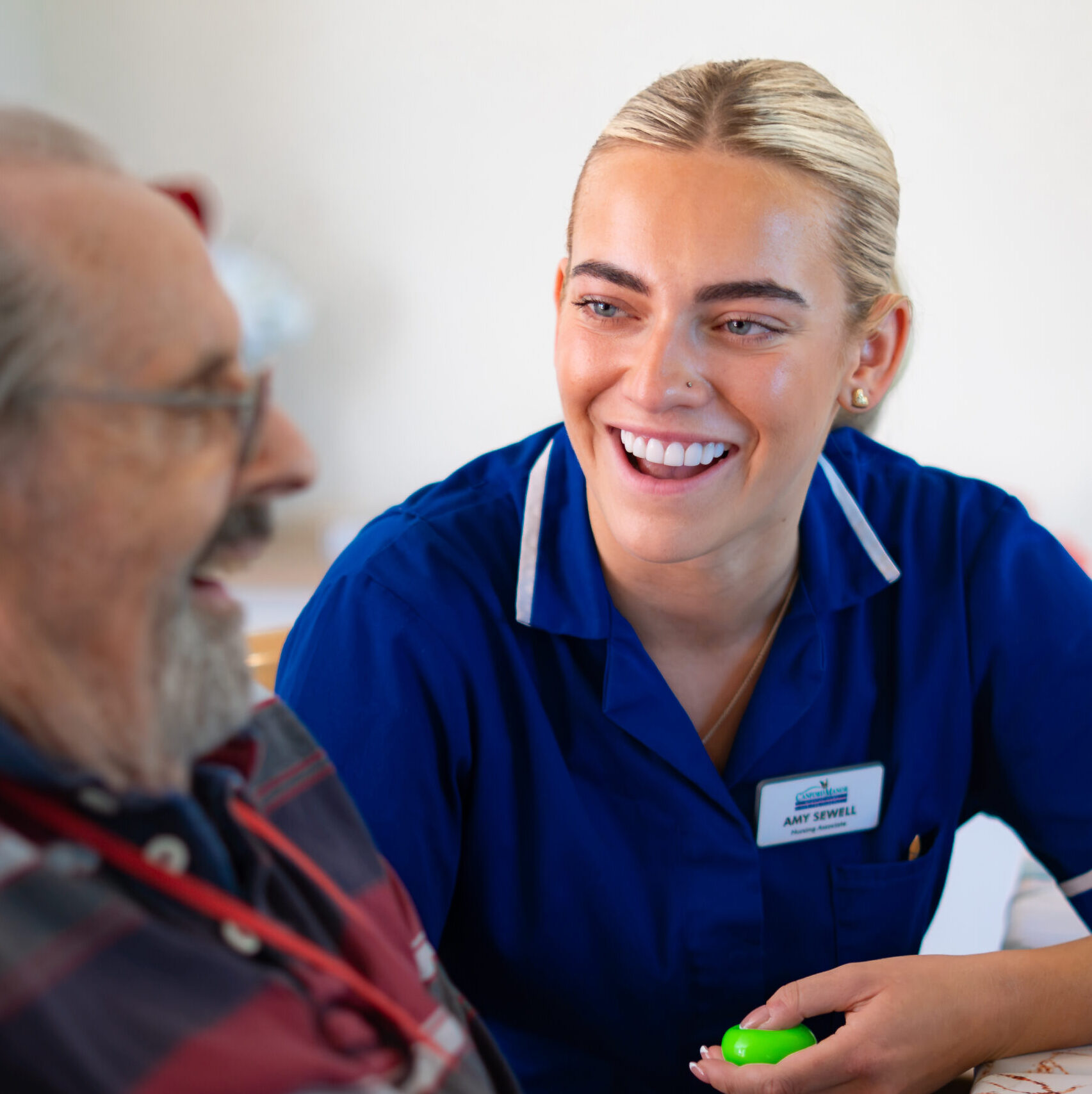 Carer sharing a laugh with a resident at Canford Manor