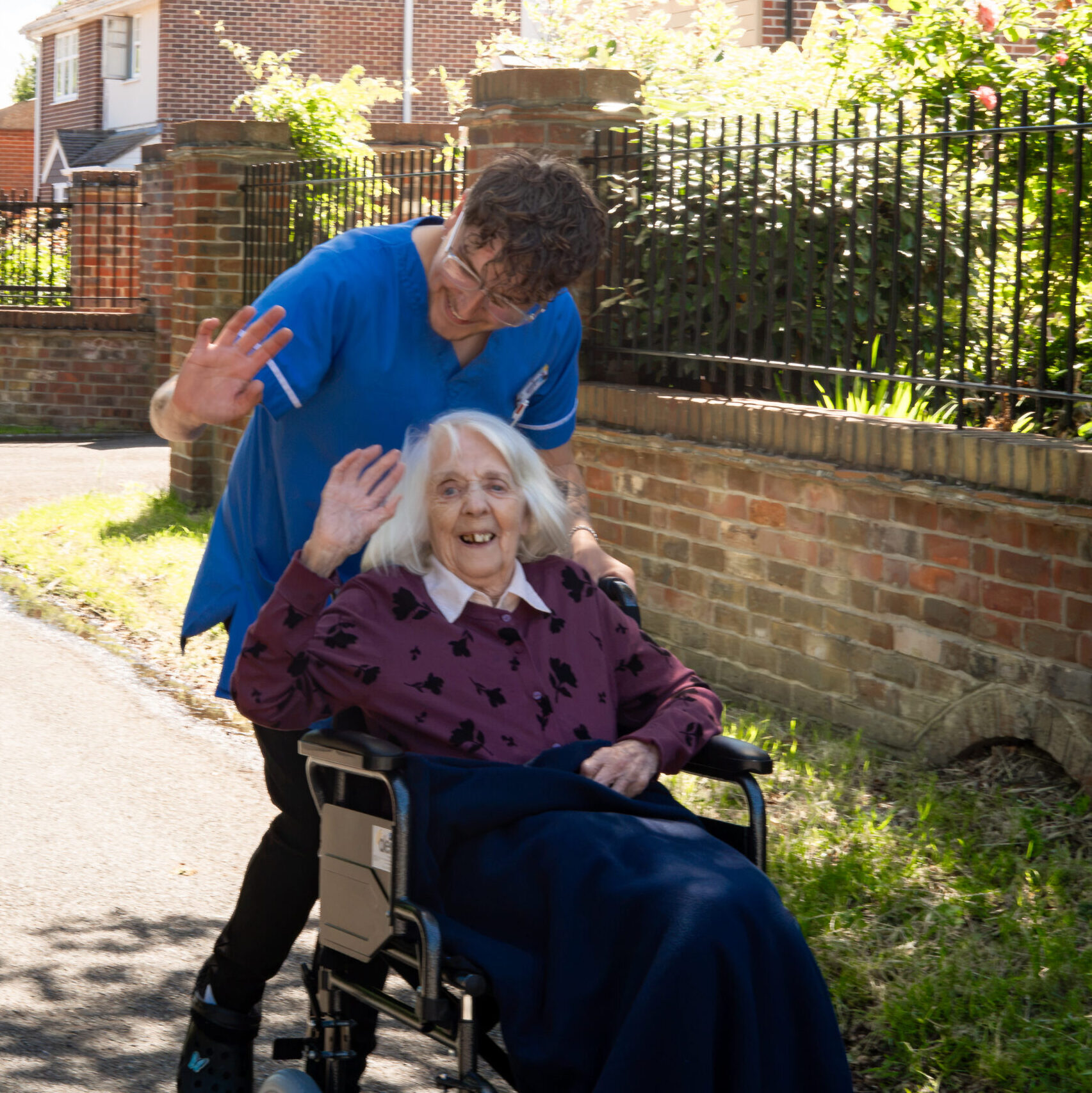 Carer taking a resident out in a wheelchair at Canford Manor