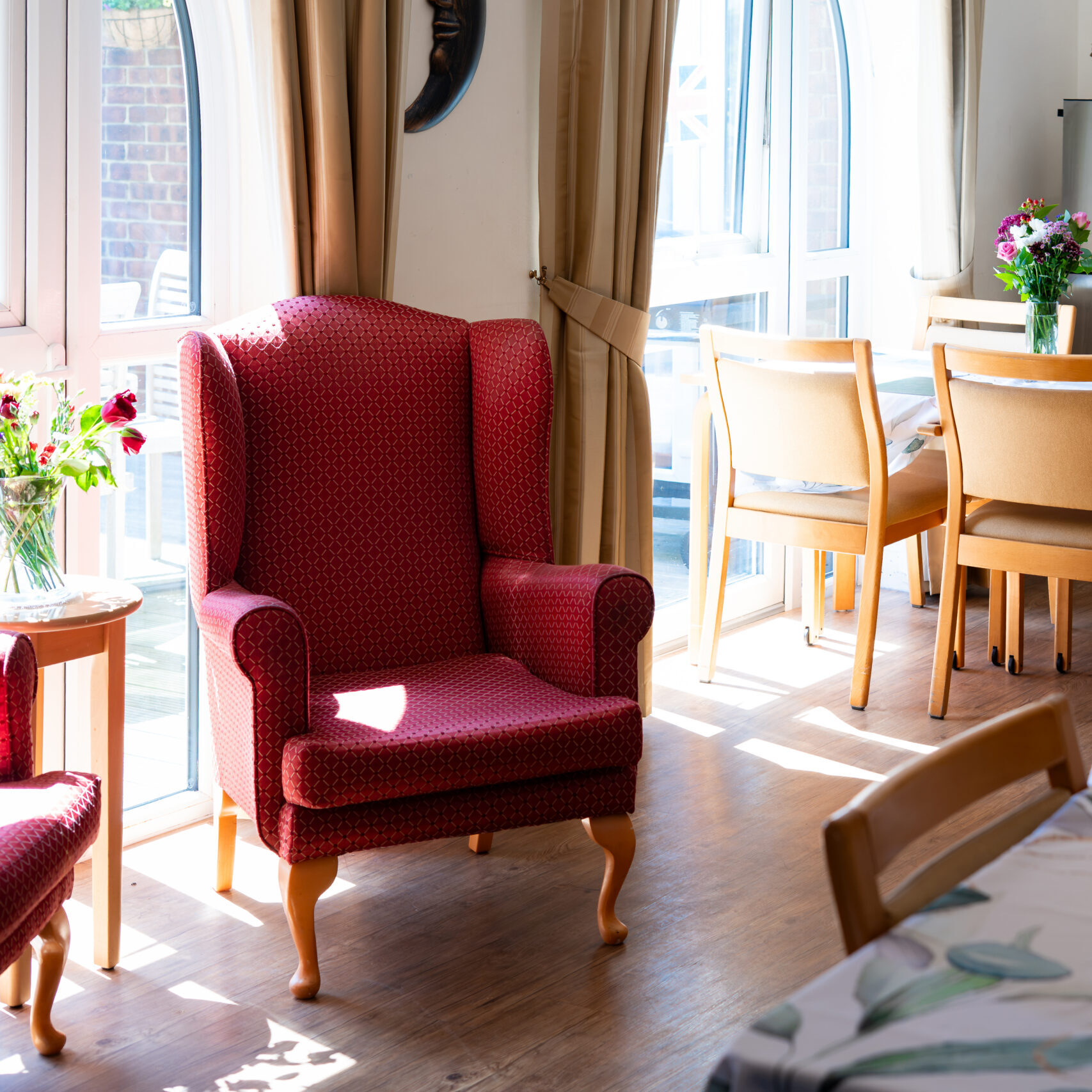 Bright sitting room with a red armchair at Canford Manor