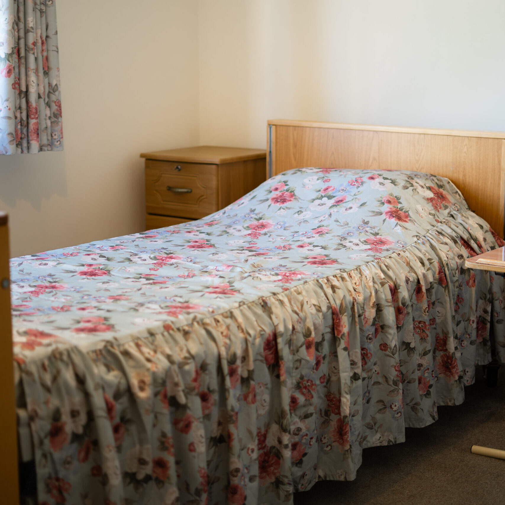 Resident's bedroom with a floral bedspread at Canford Manor